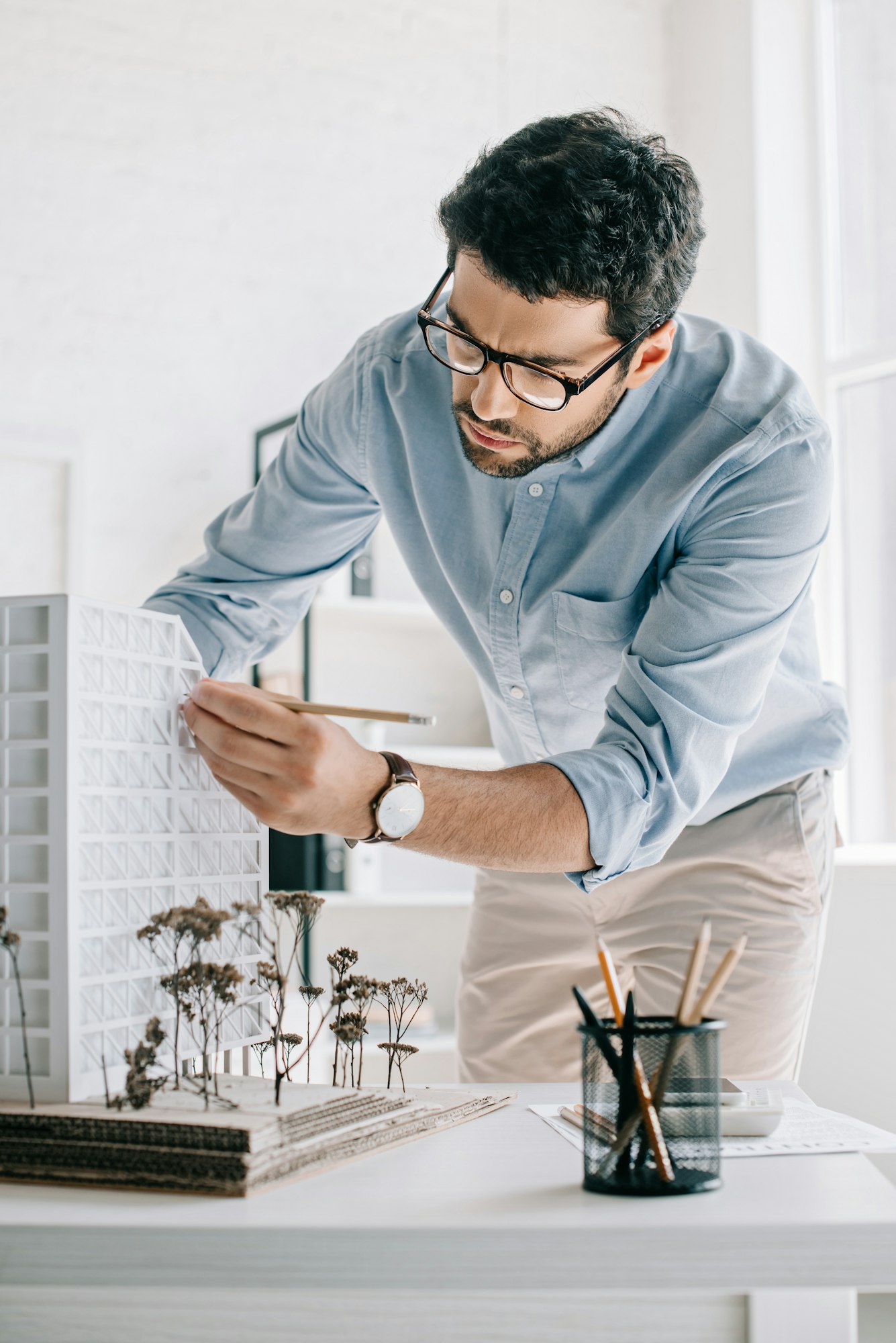 handsome architect working with architecture model on table in office