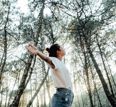 young woman breathing clean air in nature forest.Fresh outdoor, wellness healthy lifestyle concept